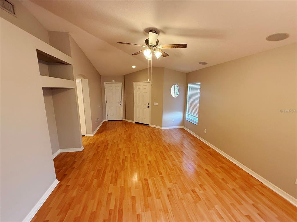 An empty room with light wood flooring, a vaulted ceiling, and a ceiling fan — 10608 NAVIGATION DRIVE, RIVERVIEW, FL