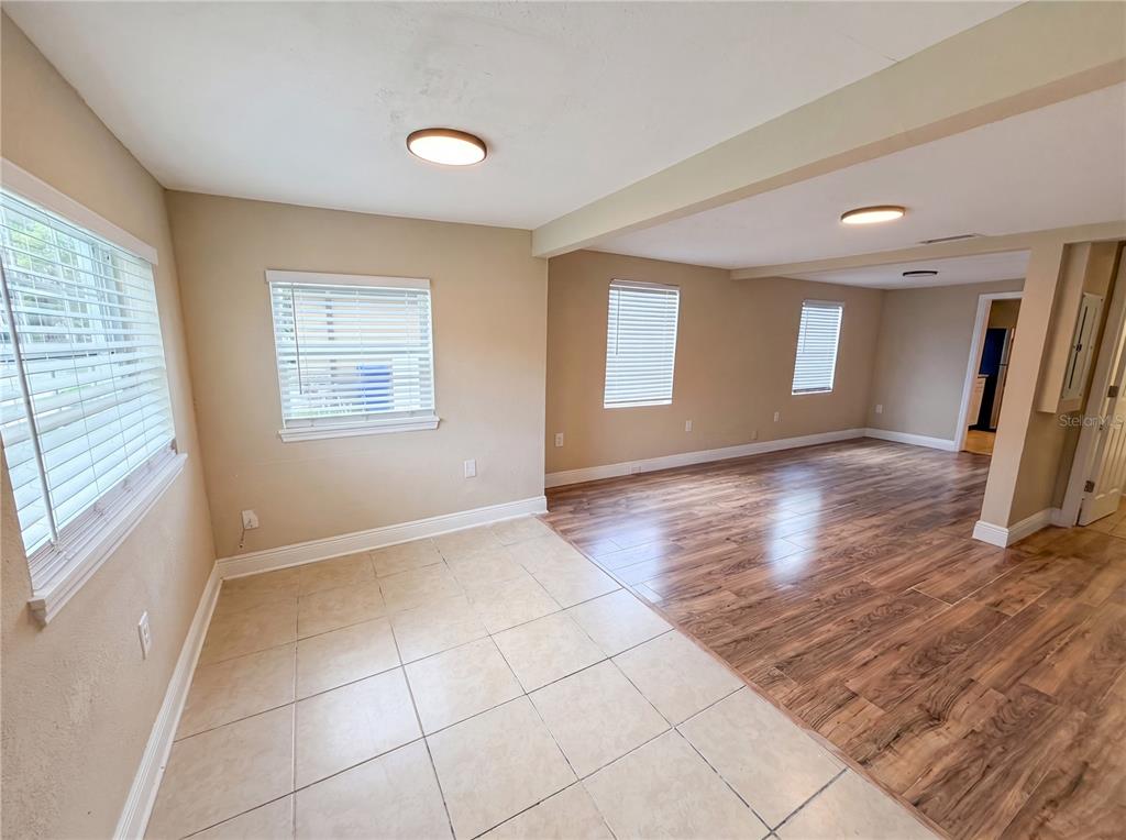 An open-concept room features a tiled dining area transitioning into a wood-floored living space — 1506 W 16TH STREET, SANFORD, FL