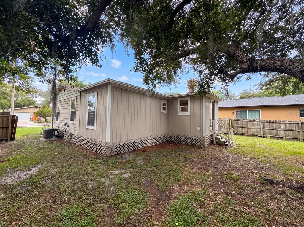 The exterior of a beige, single-story house with lattice skirting and a small wooden staircase — 1506 W 16TH STREET, SANFORD, FL