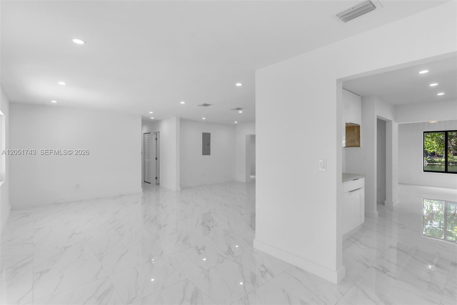 A bright, open-concept living area features white walls, recessed lighting, and polished marble flooring — 12846 SW 49th Ter, Miami FL 33175, MIAMI, FL