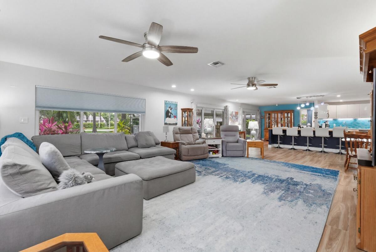 A spacious open-concept living room with a large gray sectional, area rug, and kitchen island — 904 W Cypress Lane # 46, Pompano Beach FL 33069, POMPANO BEACH, FL