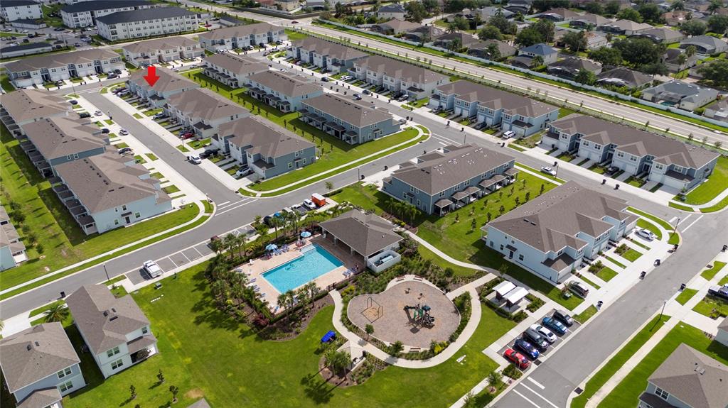 An aerial view shows a residential neighborhood with townhomes, a community pool, and a playground — 2755 FETCHING TRAIL, DAVENPORT, FL