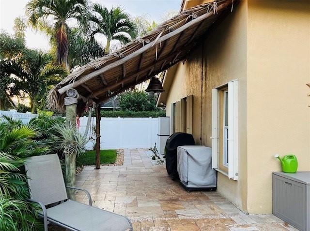 A patio area features a thatched roof, stone pavers, a lounge chair, and outdoor equipment — 6972 NW 19th Street, Margate FL 33063, MARGATE, FL