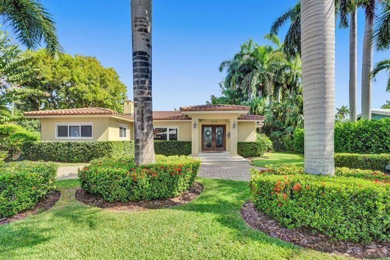 A single-story house with a tiled roof and palm trees sits behind a manicured hedge — 939 Buchanan Street, Hollywood FL 33019, HOLLYWOOD, FL