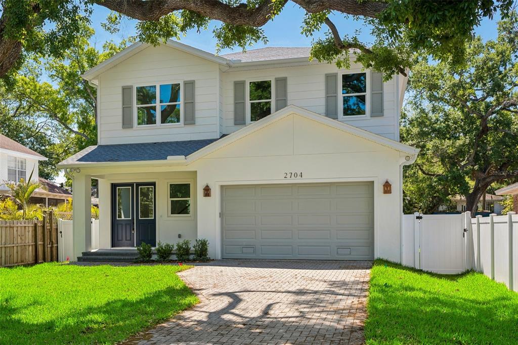 A two-story white house with a gray garage door and a paved driveway — 2704 W TYSON AVENUE, TAMPA, FL