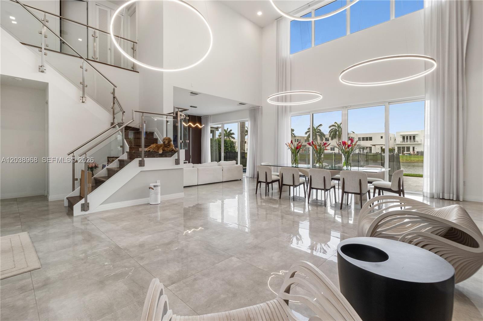 A spacious, modern living and dining area features high ceilings, large windows, and tile flooring — 10261 NW 74th Ter, Doral FL 33178, DORAL, FL