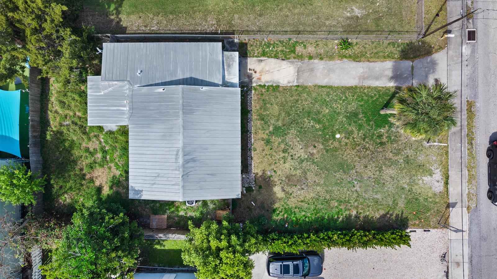 An aerial view shows a house with a metal roof, a driveway, and a yard — 820 SW Palm City Road, Stuart FL 34994, STUART, FL