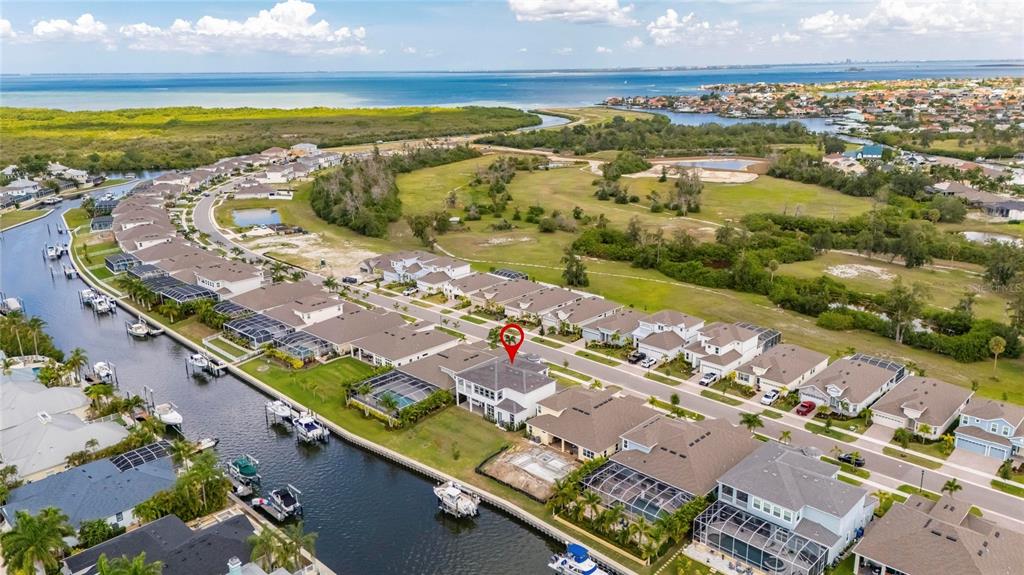 An aerial view shows a waterfront house with a red marker in a suburban neighborhood — 1016 SIGNET LOOP, APOLLO BEACH, FL