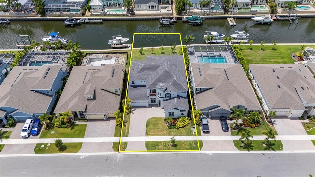 An aerial view shows a waterfront house with a pool and a private boat dock — 1016 SIGNET LOOP, APOLLO BEACH, FL