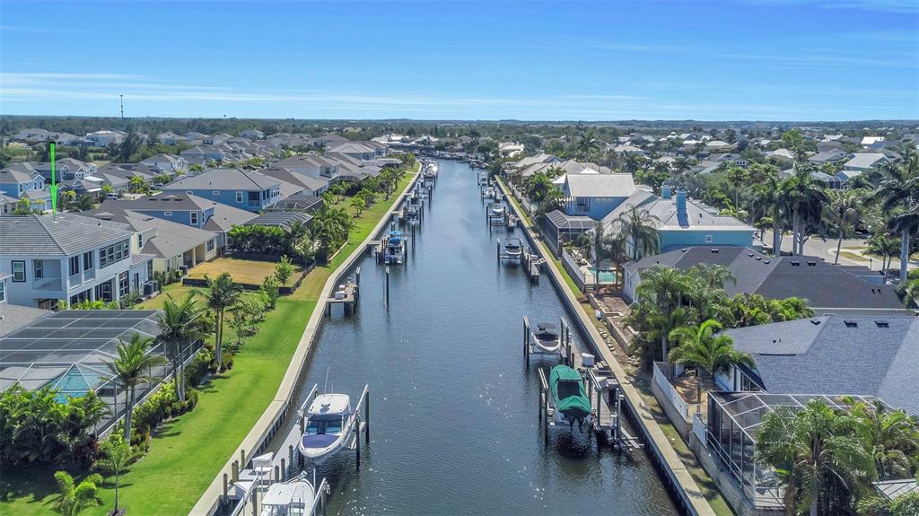 An aerial view shows a canal lined with houses, private docks, and boats — 1016 SIGNET LOOP, APOLLO BEACH, FL