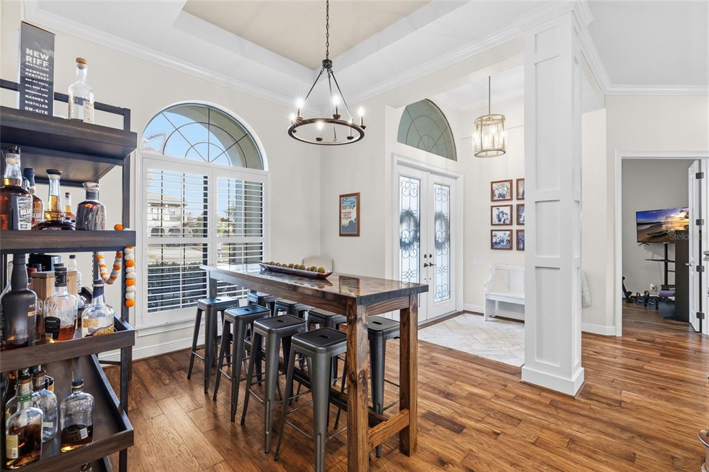 A dining area features a high-top wooden table, metal stools, and a bar cart — 16406 CHAPMAN CROSSING DRIVE, LITHIA, FL