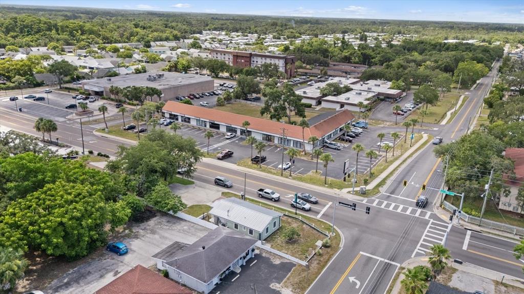 An aerial view shows a commercial strip mall with a parking lot near an intersection — 6511 MAIN STREET, NEW PORT RICHEY, FL