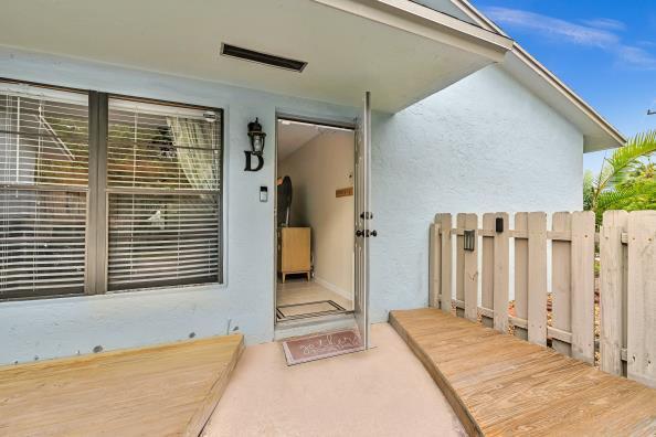 A light blue exterior wall features a wooden deck, a doorway, and a privacy fence — 431 Jupiter Lakes Boulevard # 2124d, Jupiter FL 33458, JUPITER, FL