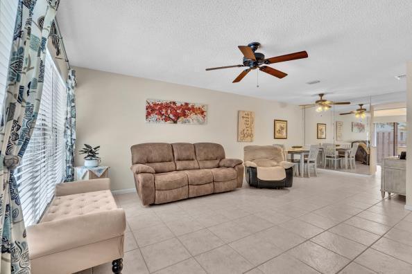A living room with tile floors, a brown sofa, a recliner, and a ceiling fan — 431 Jupiter Lakes Boulevard # 2124d, Jupiter FL 33458, JUPITER, FL