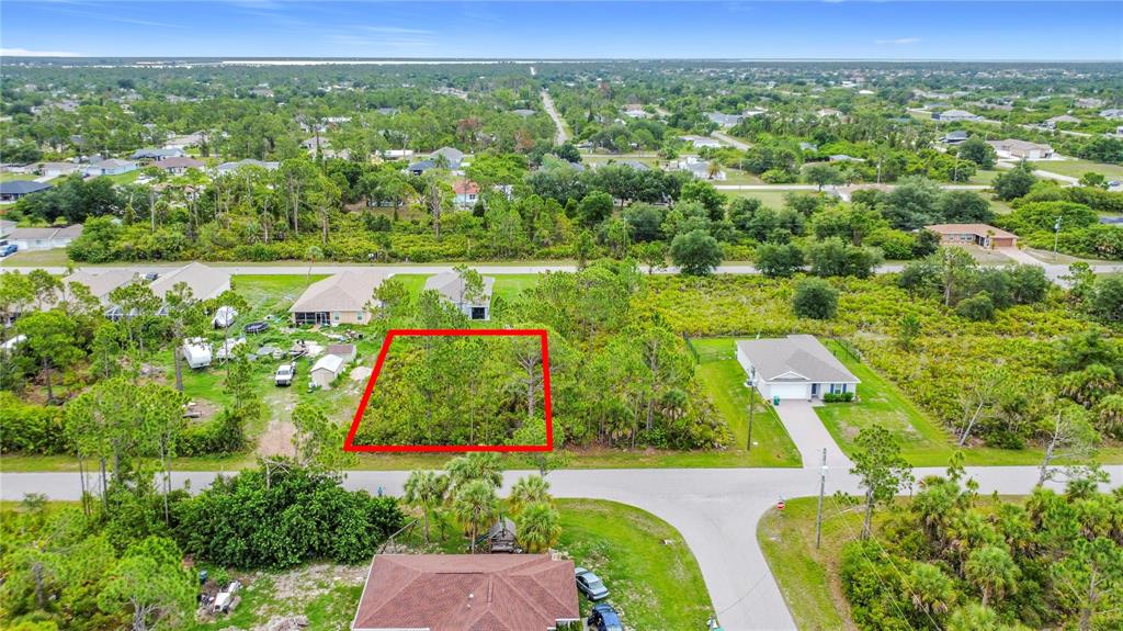 An aerial view shows a vacant, wooded residential lot outlined in red — 5464 MURPHY STREET, PORT CHARLOTTE, FL