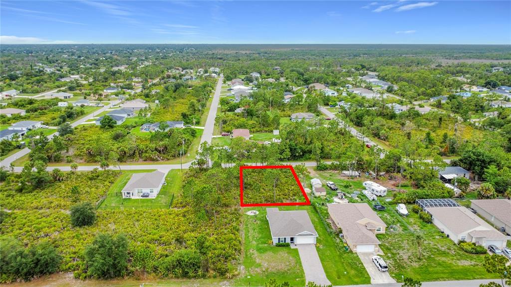 An aerial view shows a vacant rectangular lot outlined in red within a residential neighborhood — 5464 MURPHY STREET, PORT CHARLOTTE, FL