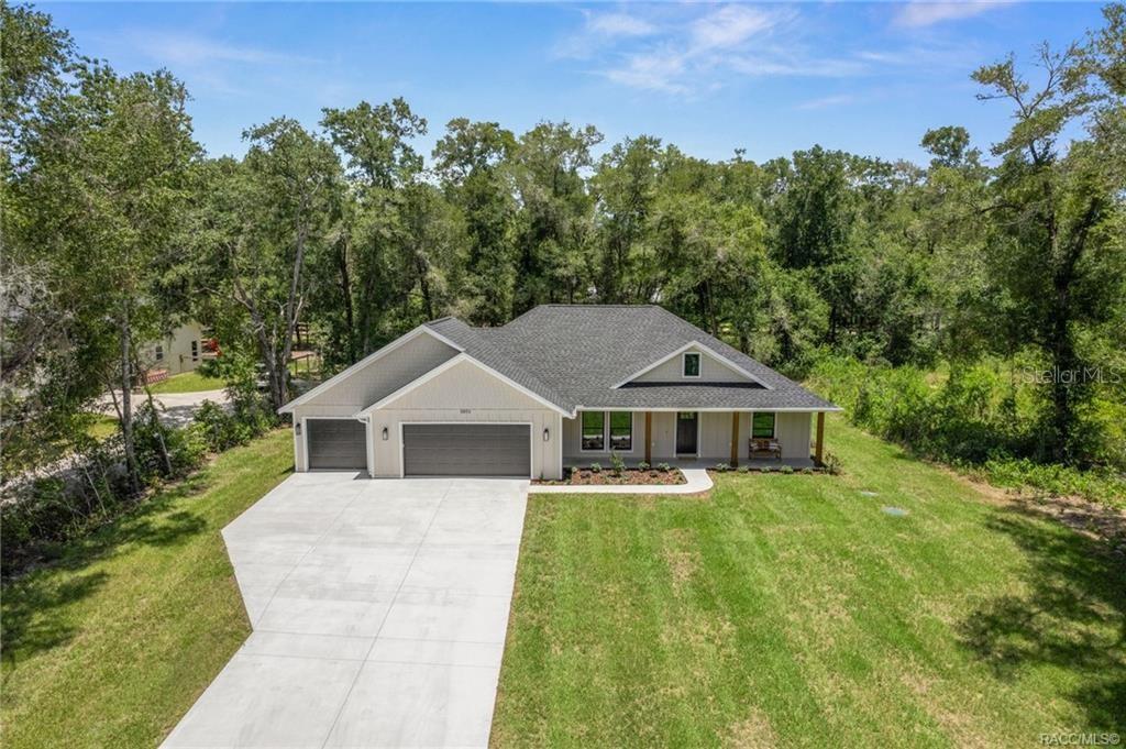 An aerial view of a single-story house with a gray roof and a concrete driveway — 3053 E ANGELINA STREET, INVERNESS, FL