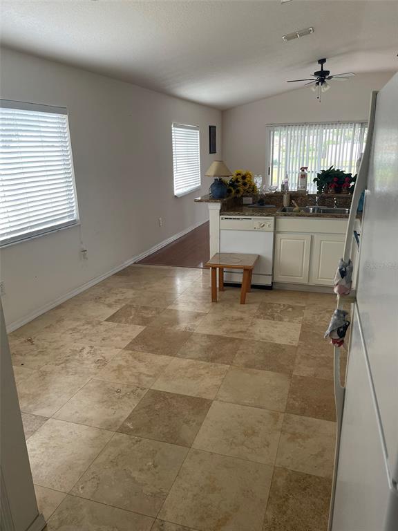 A kitchen with tile flooring, white cabinets, and a small wooden stool — 1530 OCEAN REEF ROAD, WESLEY CHAPEL, FL