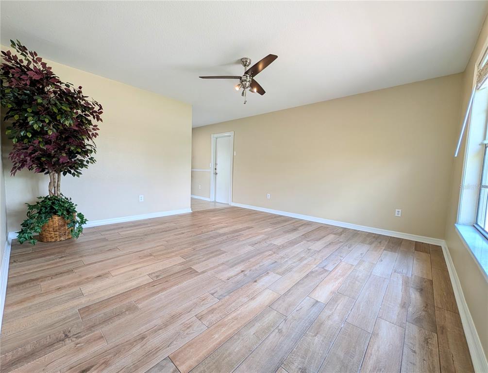 An empty room with light-colored walls, wood-look tile flooring, and a ceiling fan — 6734 STARDUST AVENUE, NORTH PORT, FL
