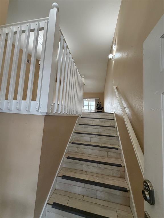 A staircase with tiled steps and a white railing leads to an upper level — 315 EAGLE RIDGE ROAD, DAVENPORT, FL