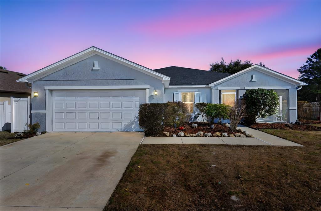 A single-story house with a two-car garage, light gray siding, and a landscaped front yard — 3339 CROTON AVENUE, DELTONA, FL