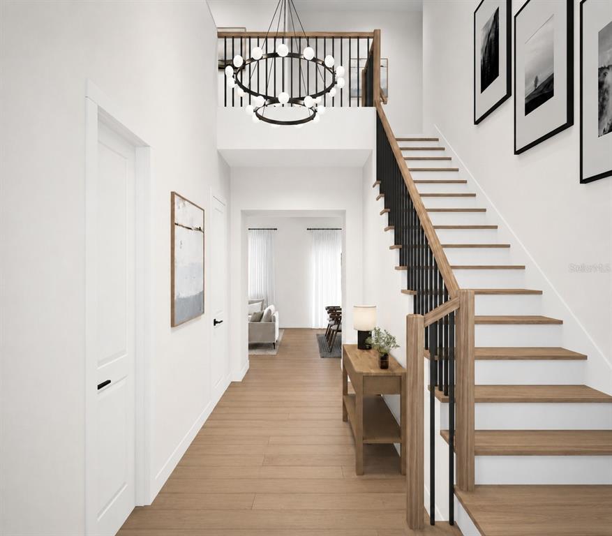 This is a rendering of a bright entryway featuring a staircase and a modern chandelier — 3706 W CLEVELAND STREET, TAMPA, FL