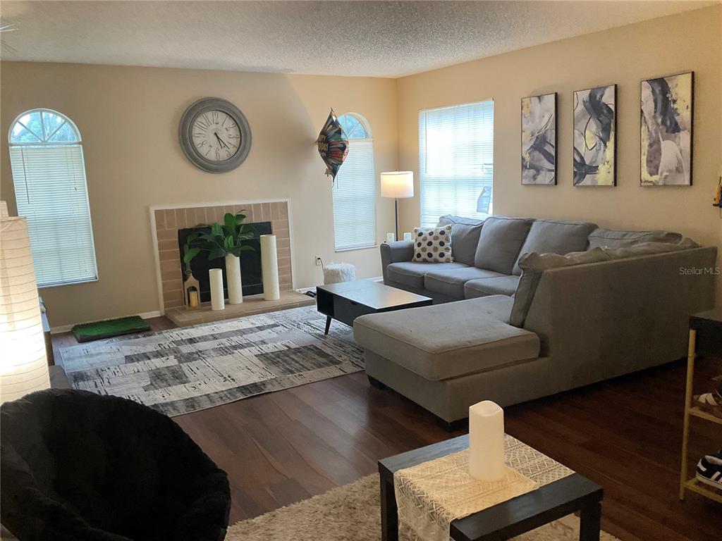 A living room features a fireplace, a sectional sofa, and a large area rug — 2197 FOX CHASE BOULEVARD UNIT 101, PALM HARBOR, FL