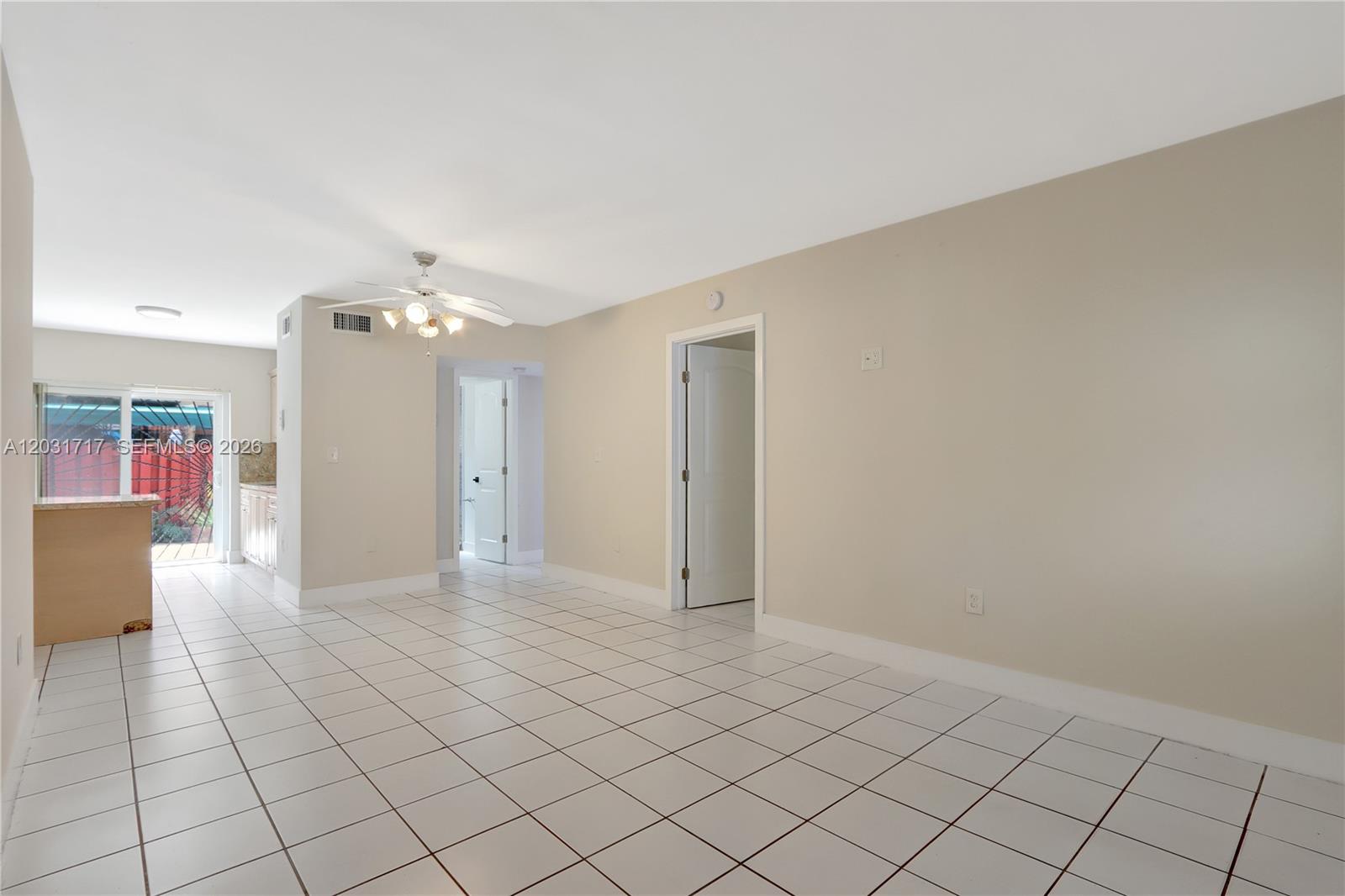 A room with white tile flooring, a ceiling fan, and a doorway leading to another area — 7732 W 29th Way # 102, Hialeah FL 33018, HIALEAH, FL