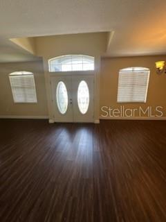 An interior view of an entryway with double doors, arched windows, and dark wood flooring — 5088 ASHWOOD DRIVE, LAKELAND, FL