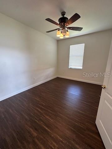 An empty bedroom features dark wood-look flooring, light-colored walls, and a ceiling fan — 5088 ASHWOOD DRIVE, LAKELAND, FL