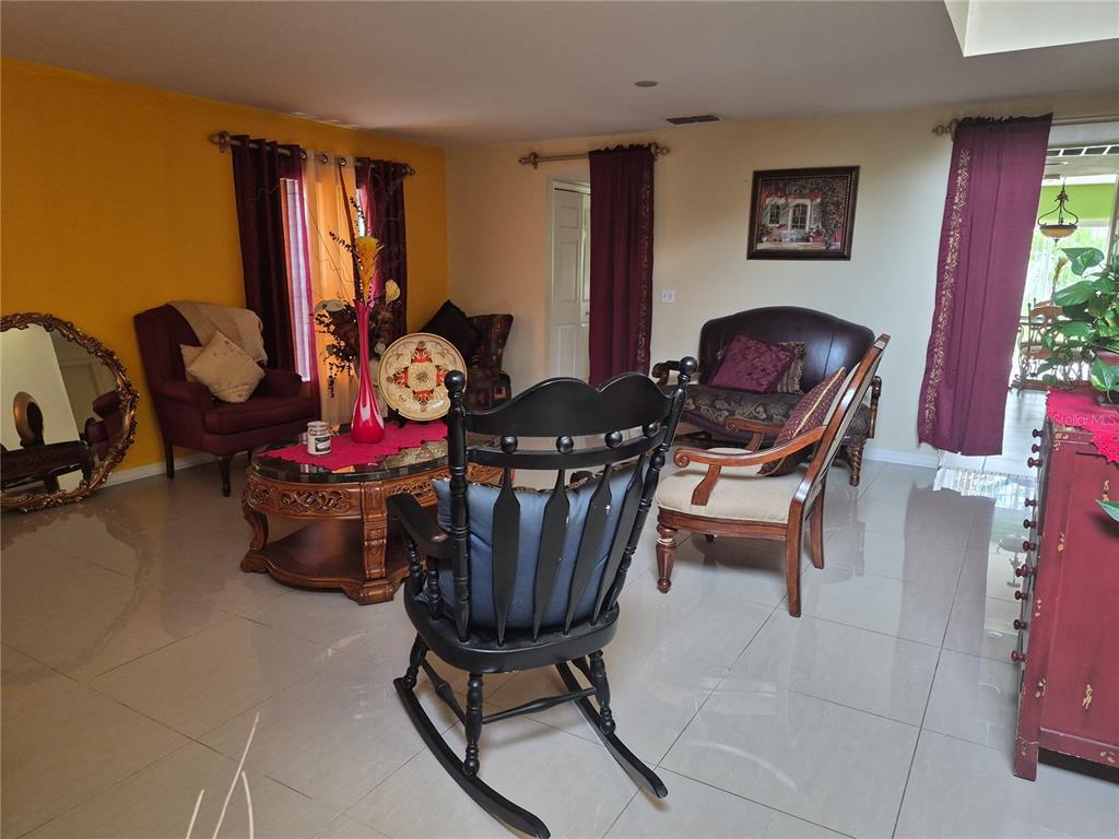 A living room features tile floors, a black rocking chair, and a wooden coffee table — 2554 PALMETTO RIDGE CIRCLE, APOPKA, FL