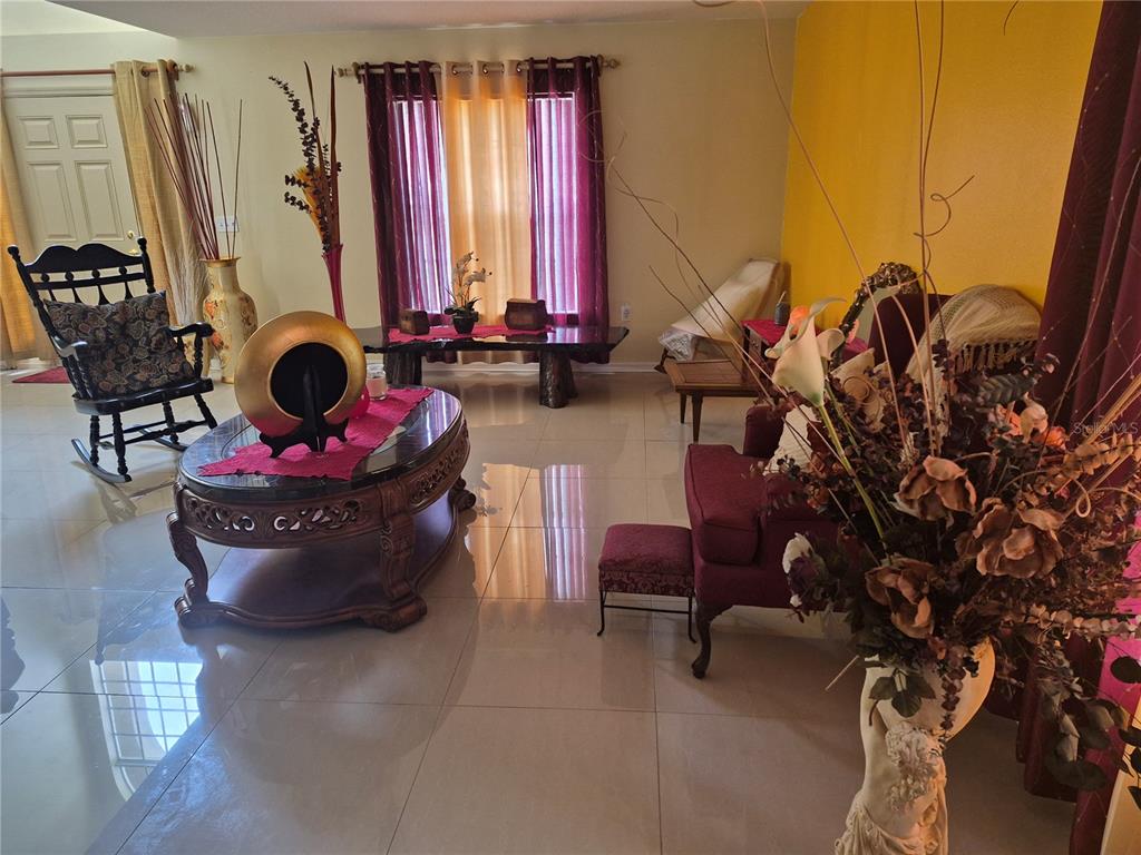 A living room features tile floors, a dark wood coffee table, and burgundy accent furniture — 2554 PALMETTO RIDGE CIRCLE, APOPKA, FL