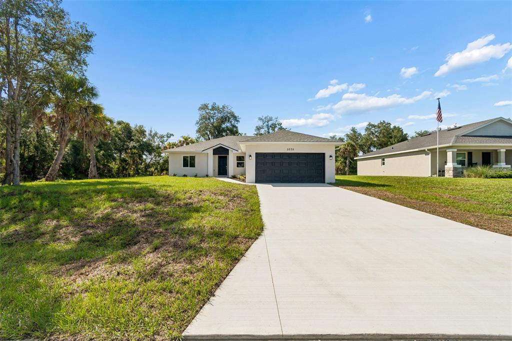 A single-story house with a concrete driveway, a two-car garage, and a grassy yard — 5535 TEVIS TERRACE, NORTH PORT, FL