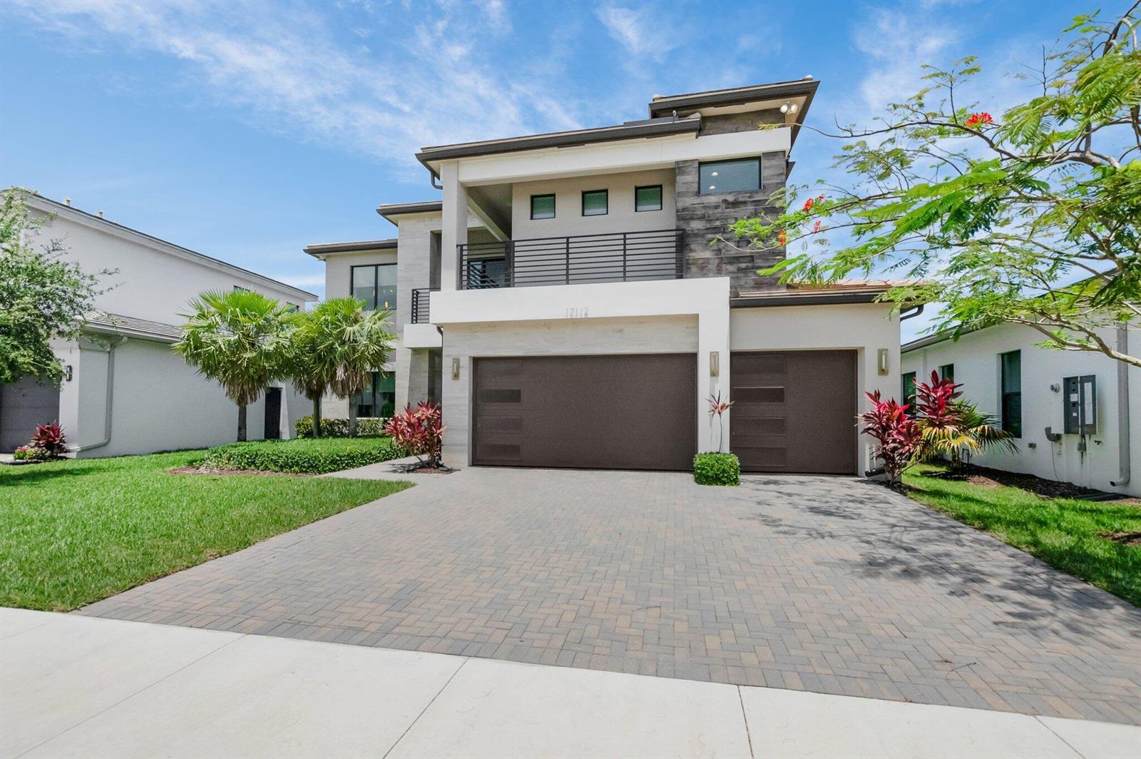 A two-story modern house features a paved driveway, a three-car garage, and a balcony — 17112 Aquavera Way, Boca Raton FL 33496, BOCA RATON, FL