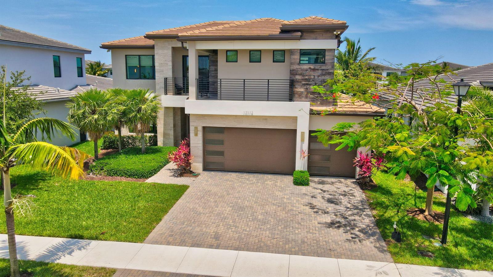 A two-story house with a paved driveway, a three-car garage, and a second-floor balcony — 17112 Aquavera Way, Boca Raton FL 33496, BOCA RATON, FL