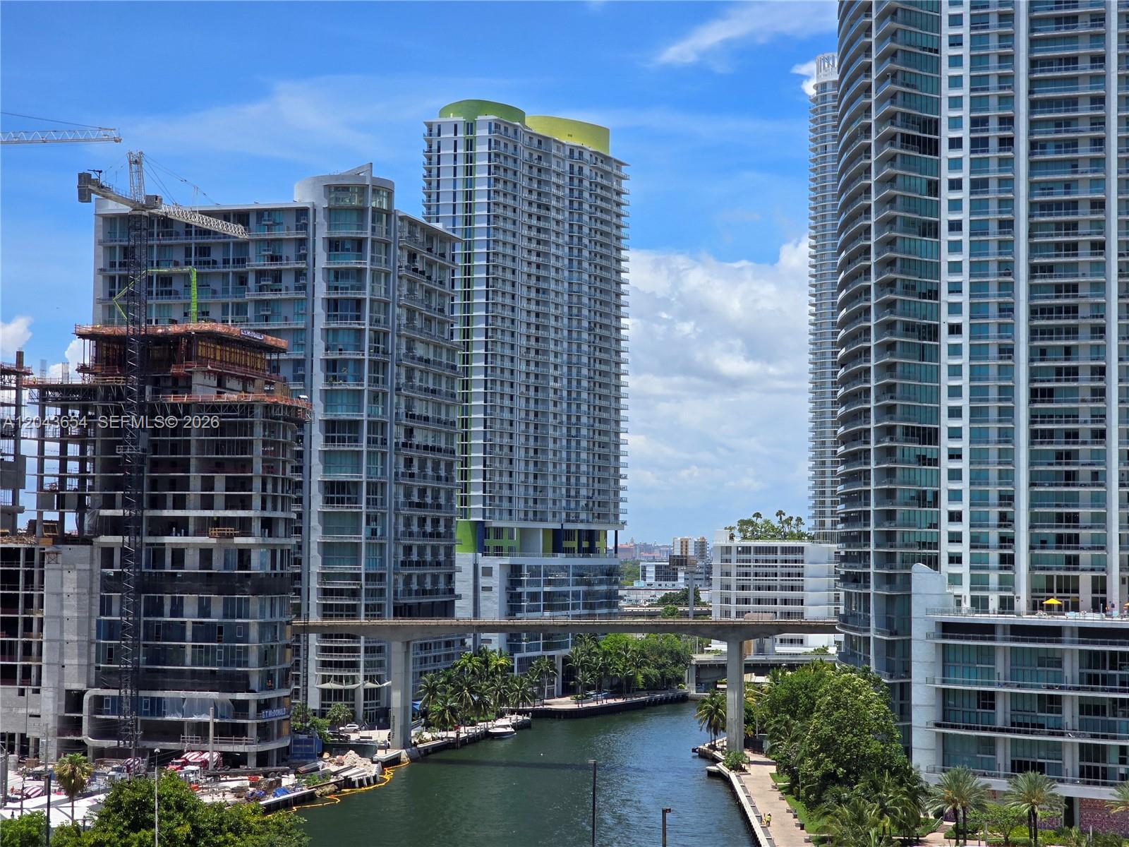 An urban canal flows between several modern high-rise buildings and a construction site — 31 SE 5th # 1203, Miami FL 33131, MIAMI, FL