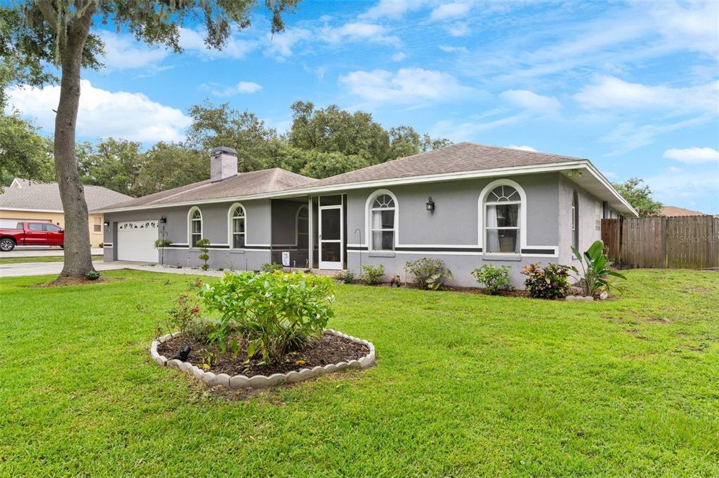 A single-story house with a gray exterior, arched windows, and a screened-in front porch — 2010 DEERBROOK DRIVE, LAKELAND, FL