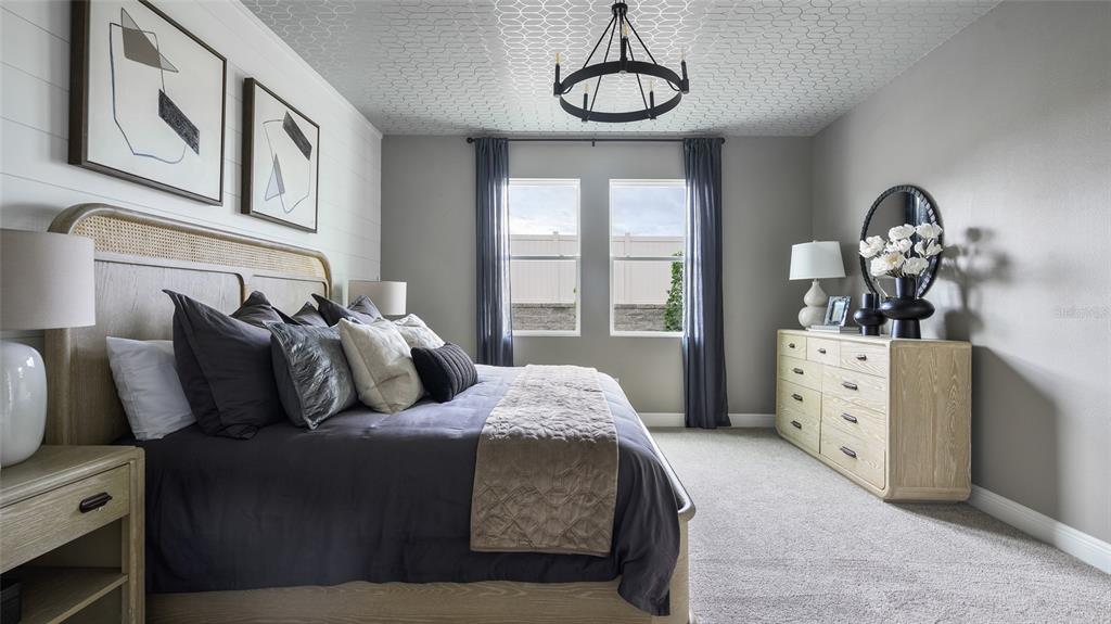 A bedroom features a bed with a rattan headboard, patterned ceiling, and a wooden dresser — 33572 HAMMOCK BEACH WAY, DADE CITY, FL