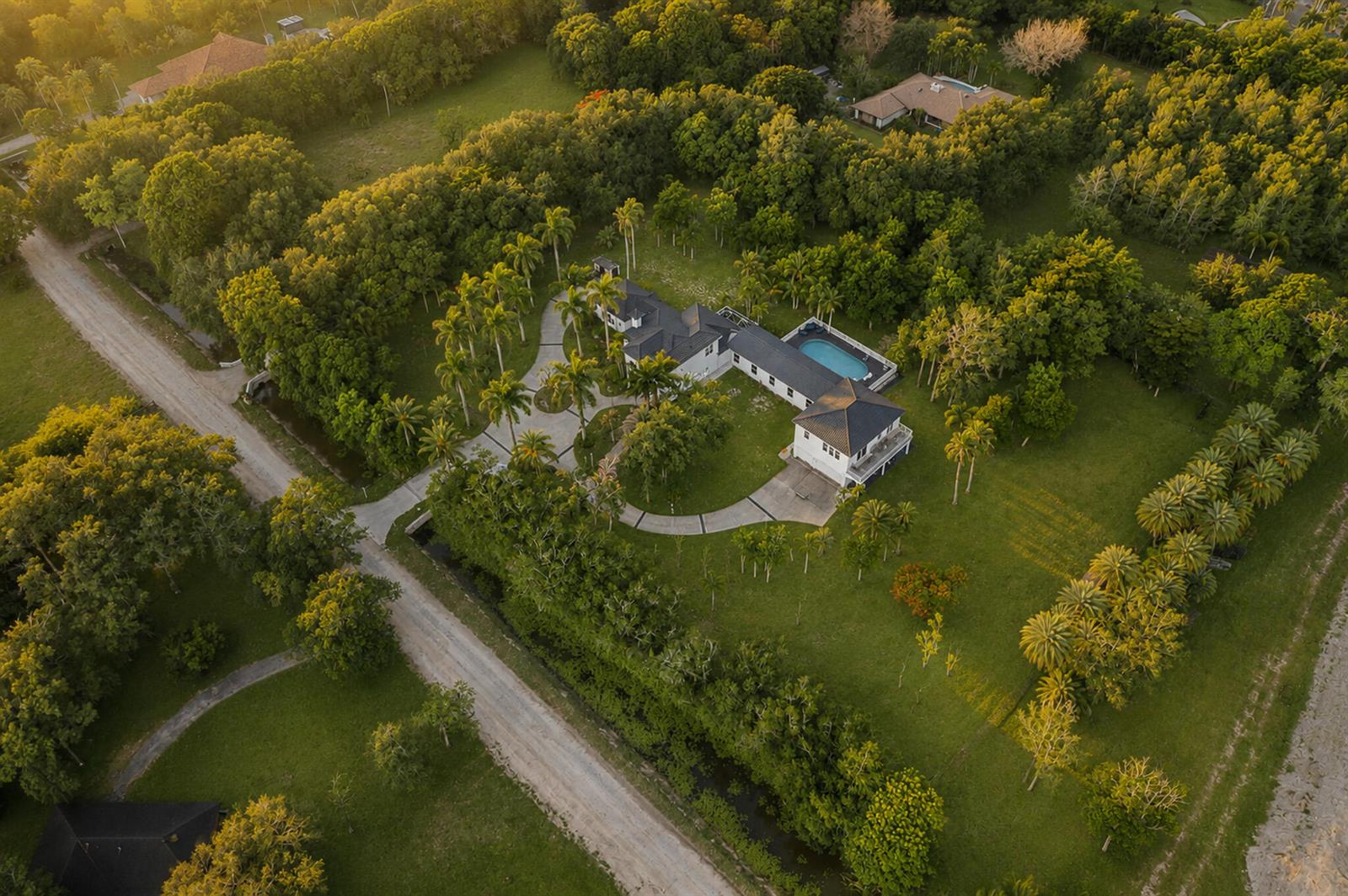 An aerial view of a large house with a pool surrounded by trees and lawns — 6911 NW 84th Avenue, Parkland FL 33067, PARKLAND, FL