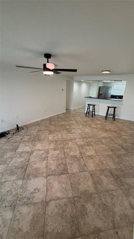 An open-concept living area features light-colored tile flooring, a ceiling fan, and a breakfast bar — 9393 MIDNIGHT PASS ROAD UNIT 806, SARASOTA, FL