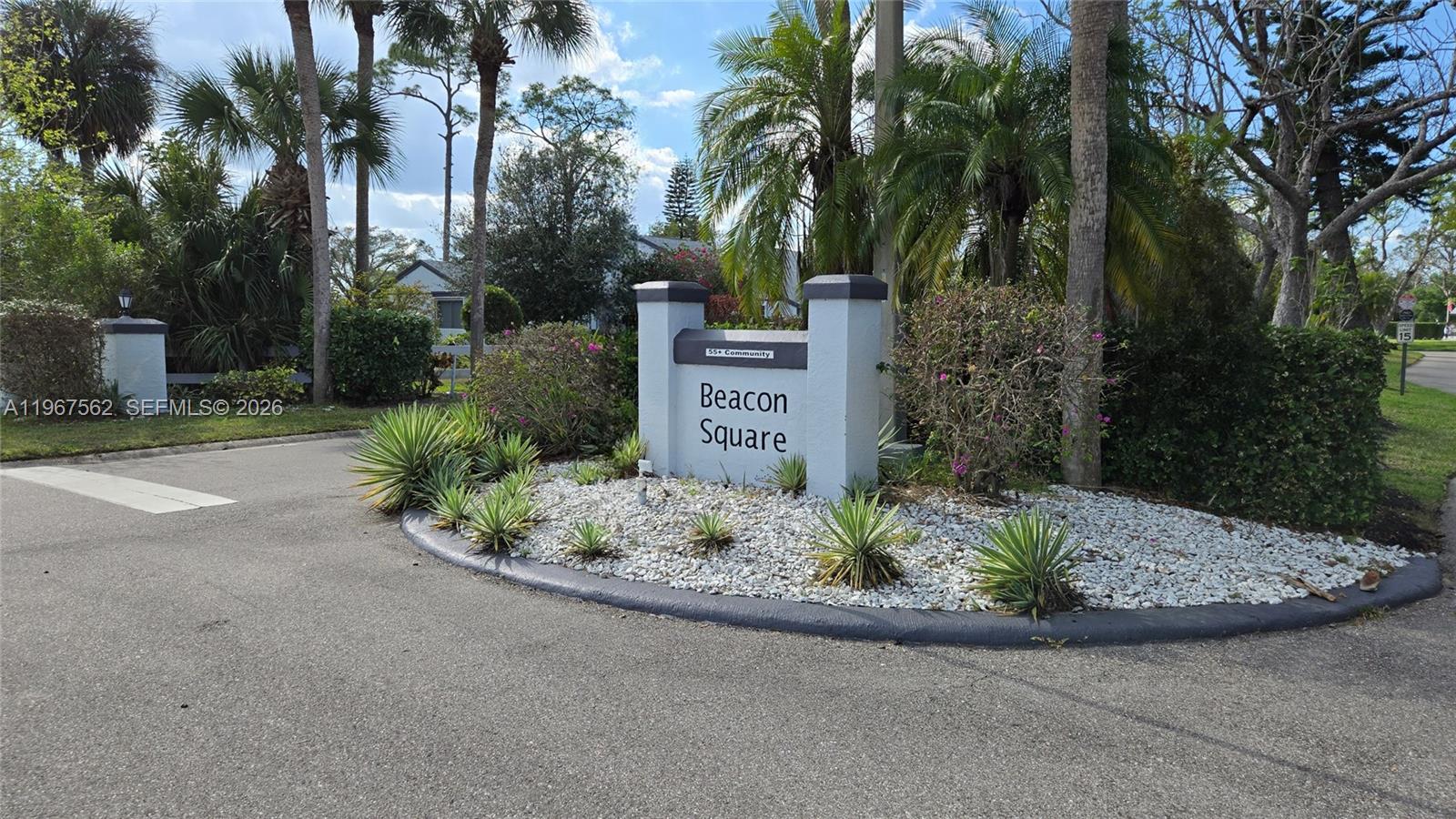 A gray monument sign for Beacon Square 55+ community stands in a landscaped traffic island — 10655 Vanceboro Ct., Lehigh Acres FL 33936, LEHIGH ACRES, FL