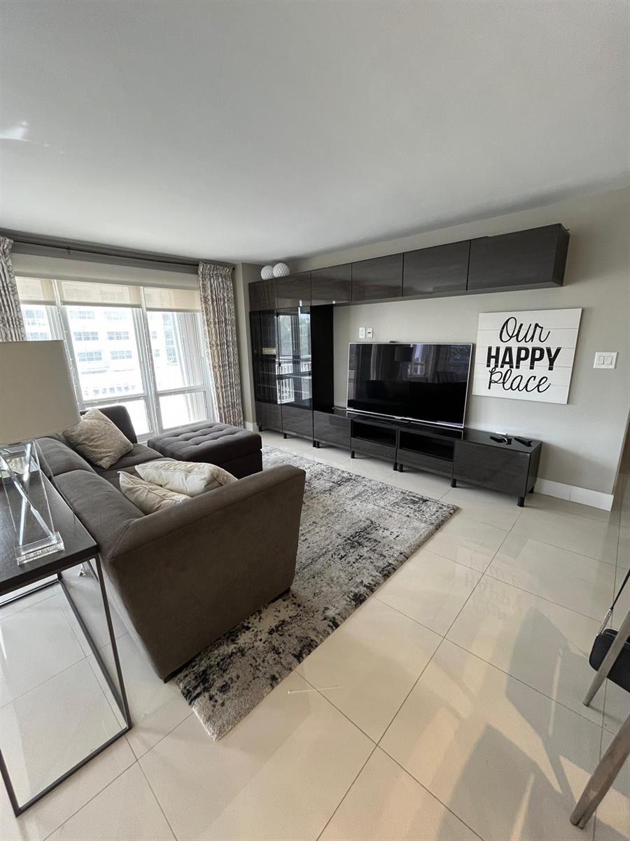 A living room features a dark grey entertainment unit, a sectional sofa, and a patterned rug — 133 N Pompano Beach Boulevard # 211, Pompano Beach FL 33062, POMPANO BEACH, FL
