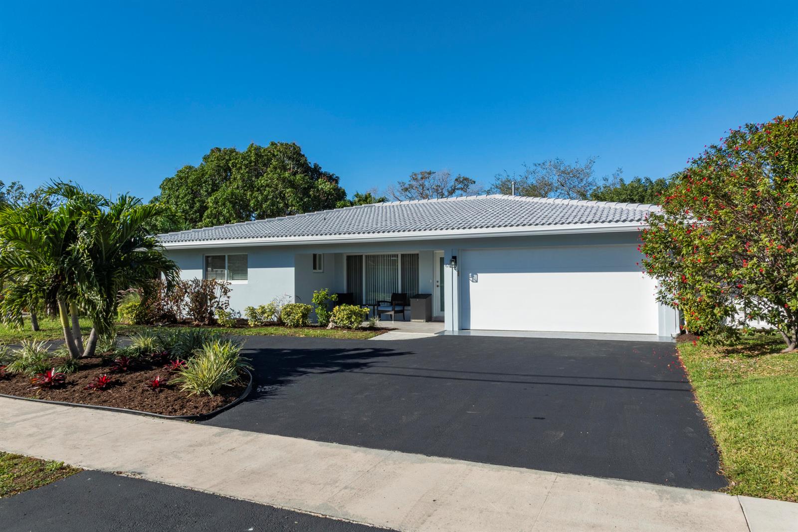 A single-story house with a white garage, light blue exterior, and a tiled roof — 421 SE 5 Terrace, Pompano Beach FL 33060, POMPANO BEACH, FL