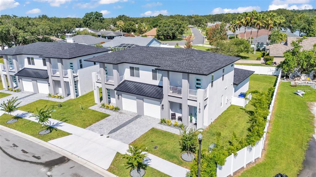 An aerial view of two modern, two-story duplex homes with white stucco and gray roofs — 1178 WINDJAMMER DRIVE, LAKELAND, FL