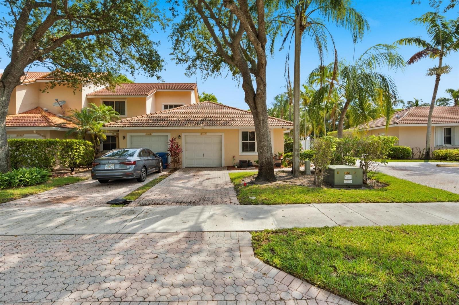 A two-story residential building with a tiled roof, paved driveway, and a parked car — 8417 NW 40th Court, Sunrise FL 33351, SUNRISE, FL