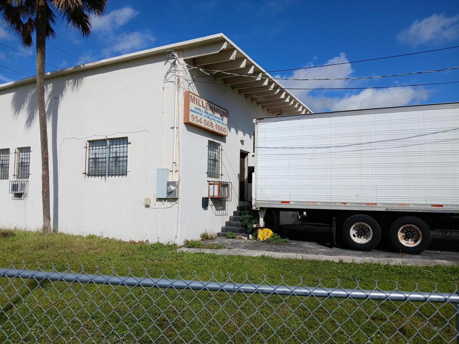 A white warehouse building with a parked semi-trailer truck and a chain-link fence — 5 NW 3rd Avenue, Dania Beach FL 33004, DANIA BEACH, FL