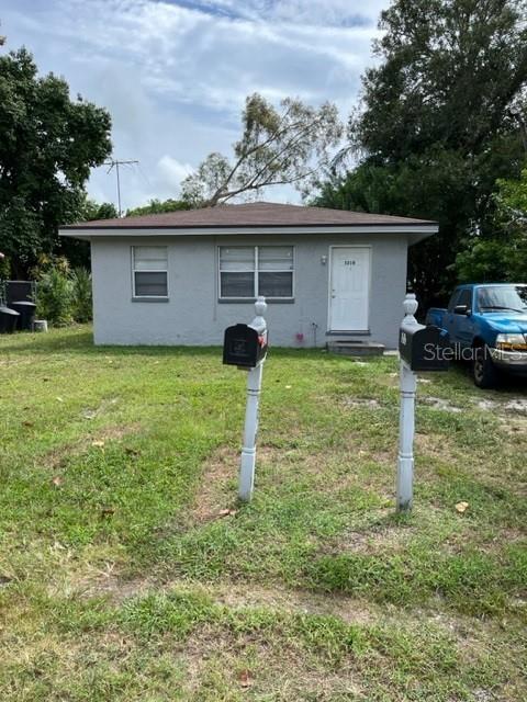 A gray, single-story house with a white front door and two mailboxes in the yard — 5210 13TH AVENUE S, GULFPORT, FL