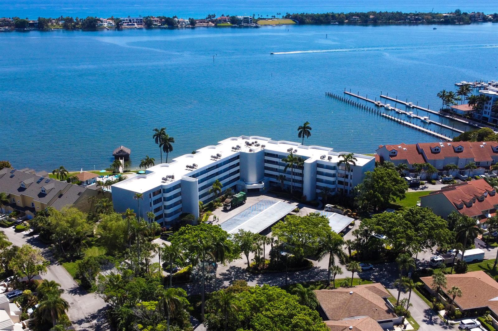 An aerial view shows a multi-story apartment building with a flat roof near the water — 8200 Lakeshore Drive # 202, Hypoluxo FL 33462, HYPOLUXO, FL