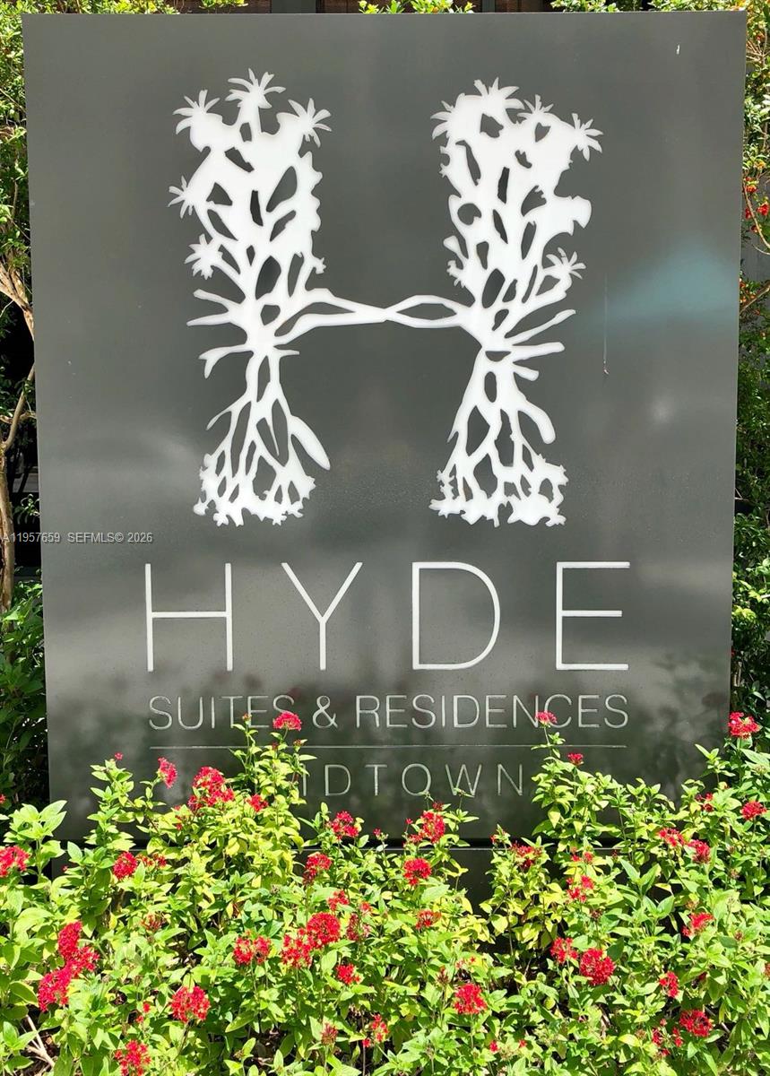 A sign for Hyde Suites & Residences Midtown stands behind a hedge of flowering plants — 121 NE 34th St # 2704, Miami FL 33137, MIAMI, FL