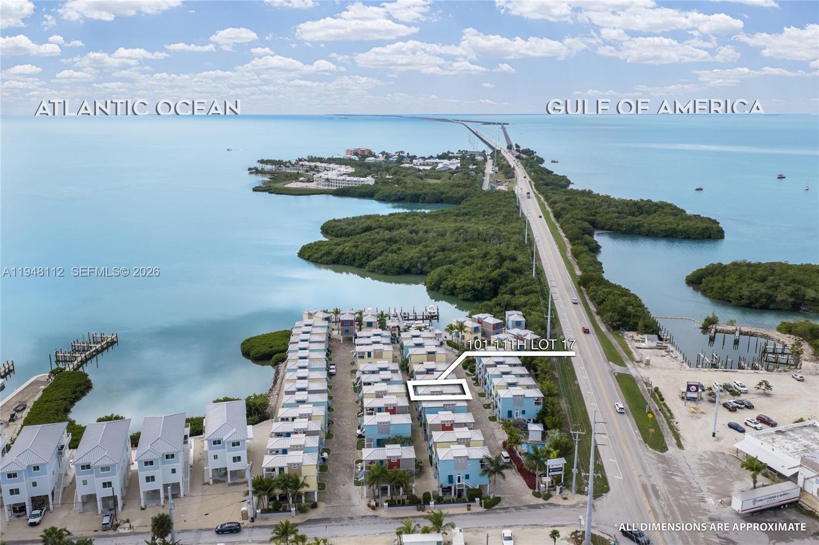 An aerial view shows a row of coastal houses near a highway and water — 101 11th Street Ocean, Unit 17, Marathon FL 33050, MARATHON, FL